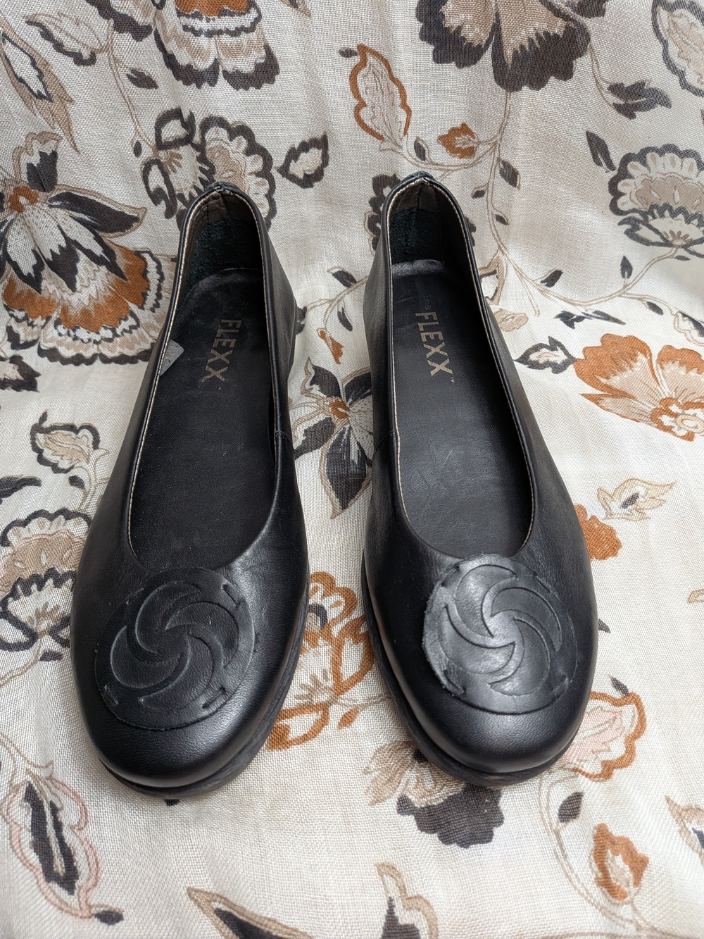 THE FLEXX Black Leather Round-Toe Ballet Flats with Swirl Medallion